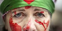 A woman wearing a Palestinian flag around her head and red paint on her face takes part in a rally supporting the Palestinian people and Lebanon, in Zurich, Switzerland, 26 October 2024.  EPA-EFE/MICHAEL BUHOLZER