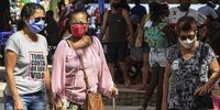 Visitors wearing face masks walk in the Sao Goncalo Municipal Centre of Northeastern Traditions on 2 August 2020 in Sao Goncalo, Brazil. The city of Sao Goncalo authorised the opening of the centre on weekends. (Photo: Luis Alvarenga / Getty Images)