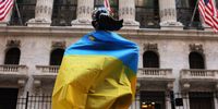 The Fearless Girl statue is seen draped in the flag of Ukraine in front of the New York Stock Exchange on 5 May 2022 in New York City. (Photo by Michael M. Santiago/Getty Images)