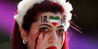  Fans hold up a shirt with the name of Mahsa Amini and a flag advocating for women's rights prior to the FIFA World Cup Qatar 2022 Group B match between Wales and IR Iran at Ahmad Bin Ali Stadium on November 25, 2022 in Doha, Qatar. People have continued demonstrating in Iran over the death of Mahsa Amini in September. Mahsa Amini fell into a coma and died after being arrested in Tehran by morality police, for allegedly violating the country's hijab rules. (Photo by Matthias Hangst/Getty Images)