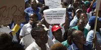 A Community Health Worker holds up a sign demanding better pay. NUPSAW claims that worker's job security is under threat at various NGOs and NPOs employing CHWs. 26 March 2019. Photo: Sandisiwe Shoba