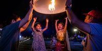 LAMPHUN, THAILAND - NOVEMBER 20: Children launch 'khom loy', lanterns, into the sky during the Yee Peng Festival on November 20, 2021 inLamphun, Thailand. The Gassan Panorama Golf Course in northern Thailand hosts its annual Yee Peng Festival, the festival of lights, where Thai's launch 'khom loy', lanterns, into the sky on the 12th Thai lunar month. Yee Peng 2021 is the first major festival held in Thailand since reopening to international tourists on November 1, 2021. (Photo by Lauren DeCicca/Getty Images)