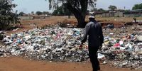 A Thembelihle informal settlement resident walks past loads of uncollected waste. (Photo: Bheki Simelane)