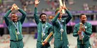 Team South Africa celebrate on the podium at the men’s  4x100m medal ceremony