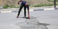 Dangawane resident Jabulile Patrick Rutsha points out damage on the R61 near Port St Johns in after protests by angry residents.  (Photo: Hoseya Jubase)