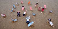 BLACKPOOL, ENGLAND - JUNE 29: Businessman Andrew Beaumont (centre) poses for the media as deck chairs for hire return to Blackpool beach for the first time in over a decade on June 29, 2021 in Blackpool, England. Local businessman Andrew Beaumont will be renting out up to 500 chairs and windbreaks to tourists each day as people return to the beaches after Covid-19 restrictions are gradually eased. (Photo by Christopher Furlong/Getty Images)
