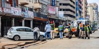 Residents and law enforcement stand along the road which collapsed following a gas explosion in the central business district on 20 July 2023 in Johannesburg, South Africa. (Photo: Gallo Images / OJ Koloti)