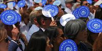 People hold fans as they listen to former US president Barack Obama speak during the dedication ceremony for the opening of his presidential centre 