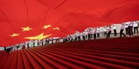 epaselect epa09499004 People display a huge Chinese flag during a ceremony celebrating China's National Day at the waterfront of the Victoria Harbour in Hong Kong, China, 01 October 2021. China celebrates its National Day on 01 October 2021, marking the 72nd founding anniversary of the People's Republic of China.  EPA-EFE/JEROME FAVRE