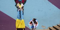 Stilt walker Andile Sohe (32) and Miss Preteen Orange Farm, Thando Mbatha (7), prepare for the annual Orange Farm Carnival, in Johannesburg, South Africa, 01 December 2024. The annual festival aims to bring the community of the township south of Johannesburg together in a spirit of 'Ubuntu', or togetherness. Organized by the Project of Nkosana Ngobese Foundation in Association with the Stretford CHC Clinic, the carnival also raises awareness to the subject of HIV/AIDS and the 16 days of activism highlighting gender-based violence in the community.  EPA-EFE/KIM LUDBROOK