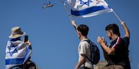 People wave flags as a helicopter carrying hostages to hospital flies over Hostages Square on October 13, 2025 in Tel Aviv, Israel. The ceasefire deal between Israel and Hamas has brought an end to the two years of war that followed the attacks of Oct. 7, 2023. A condition of the deal was the immediate return of 48 hostages held in Gaza, around 20 of whom were believed to be alive. (Photo: Chris McGrath/Getty Images)