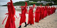 ST IVES, UNITED KINGDOM – JUNE 11:  Extinction Rebellion (XR) 'Red Rebels' activists take part in the "Sound The Alarm" march during the G7 summit in Cornwall on June 11, 2021 in St Ives, Cornwall, England. Environmental Protest Groups gather in Cornwall as the UK Prime Minister, Boris Johnson, hosts leaders from the USA, Japan, Germany, France, Italy and Canada at the G7 Summit in Carbis Bay. This year the UK has invited Australia, India, South Africa and South Korea to attend the Leaders' Summit as guest countries as well as the EU. Protest groups hope to highlight their various causes to the G7 leaders and a global audience as the eyes of the world focus on Cornwall during the summit. (Phot by Jeff J Mitchell/Getty Images)