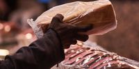 A customer selects a freshly-baked loaf of bread in the bakery section 