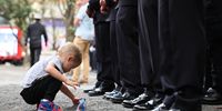 A child plays as members of FDNY stand at attention as they listen to speakers during a World Trade Center Memorial Wall dedication at the FDNY Headquarters on September 09, 2025 in New York City. Adams attended a ceremony for FDNY first responders who died recently of 9/11 related illnesses days before the 24th year anniversary of the September 11th terror attacks. A recent Sienna College poll shows that New York mayoral candidate Zohran Mamdani is holding a 22-point lead in the race for mayor of New York City ahead of Cuomo and incumbent Mayor Eric Adams. (Photo by Michael M. Santiago/Getty Images)