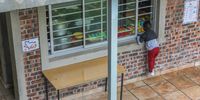 A young scholar peeks through the kitchen window to catch a glimpse of breakfast at the Kusasa Project Early Learning Centre. Their 130 scholars receive an Isabelo breakfast and lunch every day. Photo: Christi Nortier