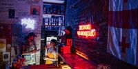 Co-owner Dariya Zheniskhan with a bartender in her bar, Ploho, in Tbilisi, Georgia, where anti-Putin graffiti adorns the walls. (Photo: Tako Robakidze/Bloomberg)
