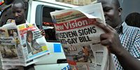 Ugandans read daily newspapers on 25 February 2014 with headlines and images of Ugandan President Yoweri Museveni signing the anti-gay legislation in Kampala, Uganda, 24 February 2014.  A controversial bill that introduces lengthy prison sentences for people who engage in homosexual acts was signed into law by Ugandan President Yoweri Museveni yesterday. The law, which has been strongly criticized by Western governments and human rights groups, punishes first-time offenders with up to 14 years in jail. People convicted of same-sex intercourse with a disabled person or a minor, as well as HIV-positive people caught engaging in homosexual acts, face life imprisonment. The law also makes it a crime not to report gay people. For the first time, lesbians are also targeted by legislation.  (Photo: EPA / RONALD KABUUBI)