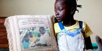 Rosita, the girl born on the top of a tree during the 2000 Mozambique floods, and was at that time an attraction of the world press, in her home showing a pillow with a picture of her baptism ceremony, Sunday 18 March 2007 in Chibuto, Mozambique. EPA/PEDRO SA DA BANDEIRA