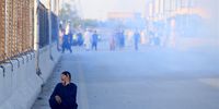 A person sits on the ground amid tear gas fired by policemen during clashes with supporters of Pakistan's former Prime Minister Imran Khan protesting against his arrest, in Peshawar, Pakistan, 09 May 2023. Khan, the chairman of Pakistan Tehreek-e-Insaf, was taken into custody by the National Accountability Bureau (NAB) on 09 May outside the Islamabad High Court, where he had arrived to appeal for bail in multiple cases filed against him. The arrest came after Khan's ouster from power in April 2020 following a failed vote of confidence in parliament.  EPA-EFE/ARSHAD ARBAB