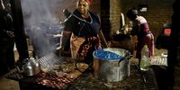 Vendors prepare meals for truck waiting at the border. Photographer: Leon Sadiki/Bloomberg