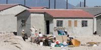 A South African family sits with their belongings outside houses in Delft, Cape Town, South Africa 19 February 2008. (Photo: Nic Bothma/ EPA)