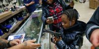 A child holds a 1911 handgun, which is inscribed with the likeness of former US President Donald Trump, at the Tommy Gun Warehouse during the annual Rod of Iron Freedom Festival in Greeley,  Pennsylvania, 07 October 2023. The festival is one of the the largest open carry festivals celebrating the 2nd Amendment in North America.  EPA-EFE/WILL OLIVER