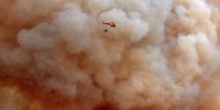 epa09618972 A helicopter pours water onto the forest fire originated in Girona, Spain, 22 July 2021. The fire has so far burnt around 20 hectares with no residential areas affected.  EPA-EFE/DAVID BORRAT