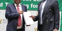 The Chairperson of National Student Financial Aid Scheme (NSFAS) Ernest Khoza (right) handing over a report to Minister Blade Nzimande on allegations against Andile Nongogo, on 17 October, 2023. (Photo: Facebook/ DHET)