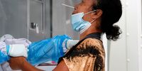epa09121825 A Thai woman reacts as she undergoes a nasal swab test for COVID-19 as an effort to curb the new wave of the coronavirus pandemic outside a closed nightclub in Bangkok, Thailand, 08 April 2021. Authorities in Thailand have ordered a two-week closure of all entertainment venues in three districts to quell the new coronavirus outbreak, after confirming 194 new COVID19 cases mostly linked to bars, nightclubs and music venues.  EPA-EFE/RUNGROJ YONGRIT