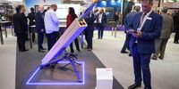 A man checks his phone as he stands next to a ground-based laser-guided rocket made by BAE Systems at the DSEI arms fair in London, 2019. (Photo: Leon Neal/Getty Images)