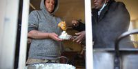 Refileo Molefe (right) who runs a soup kitchen on a inner-city farm In Bertrams johannesburg is busy dishing lunch for Maria Kock (28) one of the youth from the Bertrams community. (Photo: Denvor de Wee)