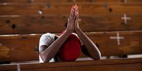 epa09346538 A person prays inside the Saint Yves church, which functions as a shelter where 1,496 people live, including 236 children, in Port-au-Prince, Haiti, 13 July 2021 (Issued 15 July 2021). Thousands of Haitians displaced from their homes as a result of gang-related territorial conflicts in Port-au-Prince have been rendered invisible by the assassination of Jovenel Moise, and their despair is mounting almost a month after fleeing the violence and losing everything.  EPA-EFE/ORLANDO BARRIA