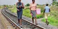 Women traveling along a railway line carrying water buckets to fetch water from hand-dug wells in the bush area along Cowdray Park in Bulawayo, Zimbabwe. (Photo: Darlington Mwashita)