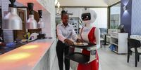 epa11572841 A robotic waiter (C) is being loaded by a human waiter with a food order to deliver to a customer at the Robot Café, the first robotic restaurant in East Africa and the second on the continent to employ humanoid robots as waiters, in Kileleshwa, Nairobi, Kenya, 29 August 2024 (issued 30 August 2024). The restaurant has been attracting tech enthusiasts and foodies since its launch two months ago. Baraka Learat, a 25-year-a first-time visitor, was captivated by this blend of technology and human interaction. “At first, I thought it was a joke, but it’s real. The robot came up, slowed down, and said, ‘Welcome.’ I wasn’t expecting that,” he says, clearly impressed. “It’s an exciting experience. I’ll definitely come back. The robots are a peek into the future, even though there’s still a human touch missing.” Despite the futuristic setup, Robot Café employs 52 staff members who work alongside the robots. Far from replacing human jobs, the robots enhance the dining experience and work in tandem with the staff. “Technology is here to stay,” the cafe manager John Kariuki notes. “The robots complement our service rather than replace it.”  EPA-EFE/DANIEL IRUNGU