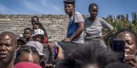 Residents watch Police Minister Bheki Cele address the media in Diepsloot. Many say they are terrorised by criminals. (Photo: Shiraaz Mohamed)