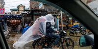 Kashmiri men take refuge under a polythene sheet to protect themselves from rainfall as they cross a bustling street on a motorcycle in Srinagar, the summer capital of Indian Kashmir, 27 April 2024. Incessant rain continues to lash over plains and higher reaches on the second consecutive day. The local meteorological department has forecast more rain during the next 48 hours in the Himalayan region.  EPA-EFE/FAROOQ KHAN