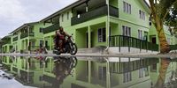 A man rides a motorbike through a puddle of water in Funafuti, Tuvalu, on 13 August 2019 (issued 15 August 2019). (Photo: EPA-EFE/Mick Tsikas)