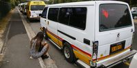 A commuter sits next to a row of parked taxis in Westlake, Cape Town, South Africa, 13 April 2015. EPA/NIC BOTHMA