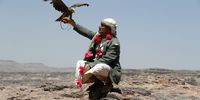 epa09068212 A Yemeni poses with a falcon on top of a mountain overlooking the Wadi Dhahr valley on the outskirts of Sana'a, Yemen, 10 March 2021 (issued 11 March 2021).  EPA-EFE/YAHYA ARHAB