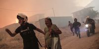 epa10998629 A  police officer evacuates an elderly lady during a wildfire at the area of Fyli near Athens, Greece, 22 August 2023.  EPA-EFE/KOSTAS TSIRONIS