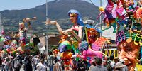 epa09670413 Sculptures and floats remain on display while groups of people come to observe them, in the streets of Pasto, Colombia, 06 January 2022. The Carnival of Blacks and Whites modified its traditional Great Parade that used to go through the streets of the city, for a sample of floats, costumes, comparsas and murgas that visitors can enjoy while walking along Carrera 27 between streets 11 and 20.  EPA-EFE/Mauricio Duenas Castaneda
