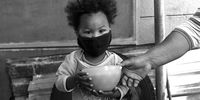 A three-year-old girl receives her daily meal of hot oats at a Cape Town feeding scheme. (Photo: Daniel Steyn)