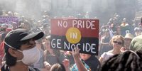 A protestor carries a placard showing the Aboriginal flag during an Invasion Day rally in Sydney, Australia, 26 January 2023. The rally was held on Australia Day, which is the official national day of Australia and is unofficially known as Invasion Day as it marks the colonization of the country's Aboriginal people.  EPA-EFE/DIEGO FEDELE  AUSTRALIA AND NEW ZEALAND OUT