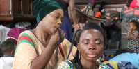 A woman sits patiently as a fellow displaced migrant braids her hair into tight cornrows. Despite the terrible conditions in the Central Methodist Church in Cape Town, many refugees are continuing with life as normal on 8 January 2020. Photo: Sandisiwe Shoba<br>