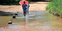 Women walk across a river on their way from a clinic in HaMatsila, Limpopo . The village which now enjoys access to clean running water is located about 60km from the Nandoni dam where a woman was devoured by a crocodile while drawing water earlier this year. (Photo: Lucas Ledwaba/Mukurukuru Media)