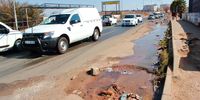 Motorists drive past leaking water along Mphuti Street on July 8, 2021 in Soweto, South Africa. (Photo by Gallo Images/Fani Mahuntsi)