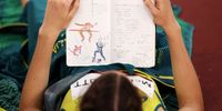 TOKYO, JAPAN - AUGUST 07: Nicola McDermott of Team Australia reads her journal as she competes in the Women's High Jump Final on day fifteen of the Tokyo 2020 Olympic Games at Olympic Stadium on August 07, 2021 in Tokyo, Japan. (Photo by David Ramos/Getty Images)