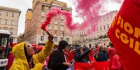 A protester lets off a colored smoke bomb during a protest by members of auto workers unions, over declining production, in Rome, Italy, on Friday, Oct. 18, 2024. Italy's car industry faces an existential threat if manufacturers led by Stellantis NV don't reverse a trend of declining production in the country, according to an automotive trade group. Photographer: Stephanie Gengotti/Bloomberg via Getty Images