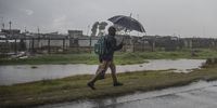 A man walks along the N2 in the pouring rain near Khayelitsha. (Photo Brenton Geach)