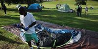 A homeless man breaks down his tent and gathers his belongings at an encampment August 14, 2025 in in the Foggy Bottom neighborhood of Washington, DC.  D.C. city officials put notices at the camp that they would be breaking down the homeless encampment.   (Photo by Win McNamee/Getty Images)